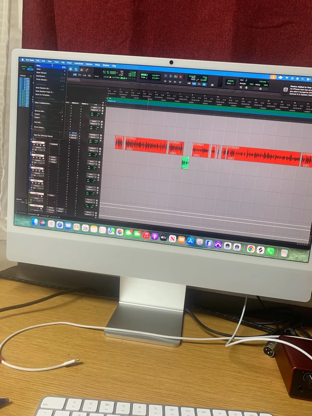A Pro Tools session open on the iMac, the vocal regions in red